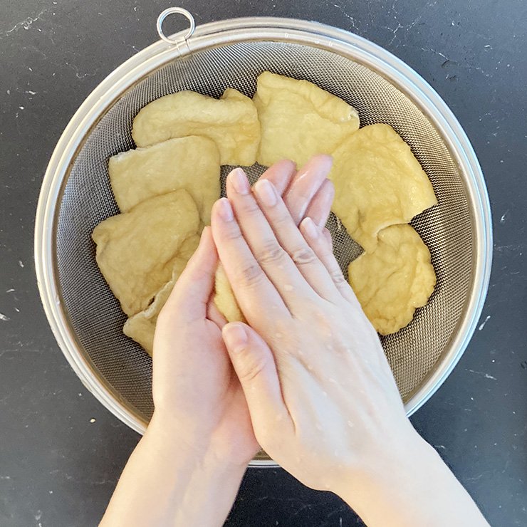 ザル等に引きあげて、粗熱が取れたら水気を絞ります。