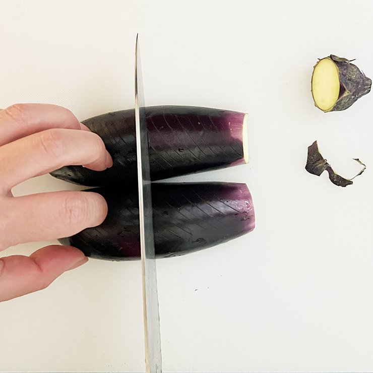 ナスはヘタを取り、縦半分に切り、皮目に切り込みを入れて、長さを半分にします。